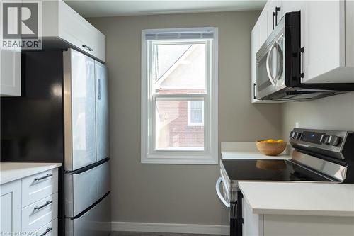 Kitchen featuring appliances with stainless steel finishes, white cabinets, and light stone counters - 39 Cloverhill Road, Hamilton, ON - Indoor Photo Showing Kitchen