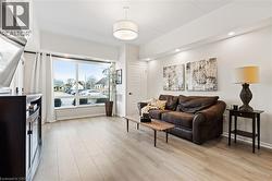 Living room with light wood-style flooring and recessed lighting - 