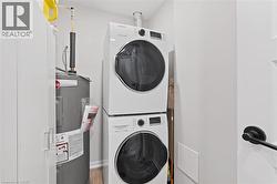 Laundry room featuring water heater and stacked washer / drying machine - 