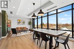 Dining area featuring a raised ceiling, floor to ceiling windows, light wood-type flooring, and recessed lighting - 