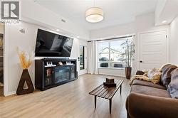 Living area featuring light wood finished floors, recessed lighting, and a glass covered fireplace - 