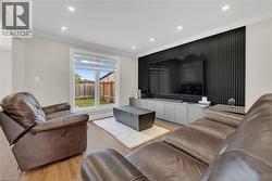 Living area with crown molding, wood finished floors, and recessed lighting - 