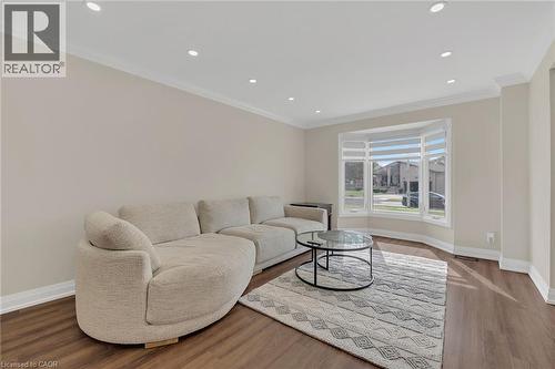 Living room with crown molding, wood finished floors, and recessed lighting - 125 Valera Drive, Hamilton, ON 