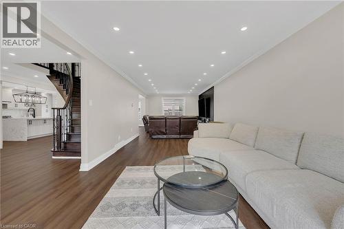Living area featuring recessed lighting, crown molding, dark wood-style floors, and stairs - 125 Valera Drive, Hamilton, ON 