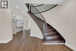Stairway with wood finished floors, ornamental molding, and recessed lighting - 