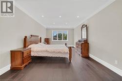 Bedroom featuring crown molding, dark wood finished floors, and recessed lighting - 