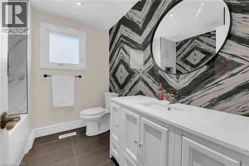 Full bathroom with vanity, dark tile patterned flooring, tub / shower combination, and recessed lighting - 125 Valera Drive, Hamilton, ON 