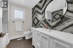 Full bathroom with vanity, dark tile patterned flooring, tub / shower combination, and recessed lighting - 