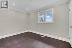 Spare room featuring crown molding, dark wood finished floors, and recessed lighting - 