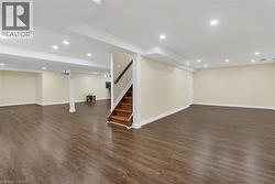 Finished basement featuring recessed lighting, dark wood finished floors, and stairs - 