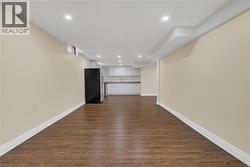 Unfurnished living room featuring dark wood-type flooring and recessed lighting - 