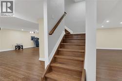 Staircase featuring recessed lighting and wood finished floors - 