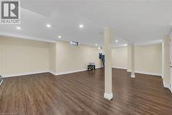 Finished below grade area with dark wood-style floors and recessed lighting - 