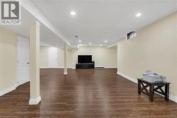 Finished basement with dark wood-style floors and recessed lighting - 