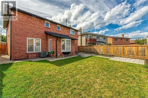 Rear view of house featuring brick siding, a fenced backyard, and a patio - 125 Valera Drive, Hamilton, ON 
