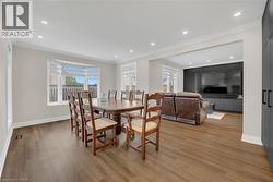 Dining room with crown molding, light wood finished floors, and recessed lighting - 