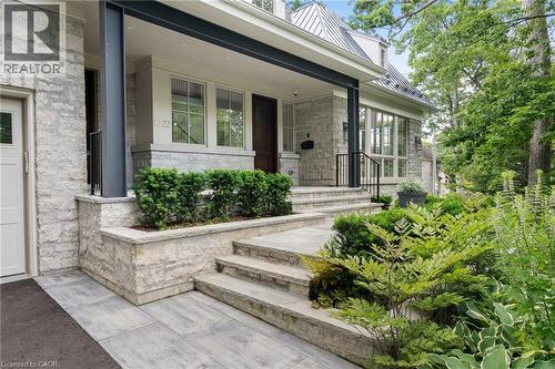 View of exterior entry with stone siding, a standing seam roof, covered porch, and a metal roof - 1322 Minaki Road, Mississauga, ON - Outdoor