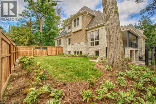 Rear view of house with stone siding, a fenced backyard, a shingled roof, and a balcony - 1322 Minaki Road, Mississauga, ON - Outdoor