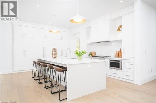 Kitchen featuring a kitchen breakfast bar, white cabinets, a center island with sink, hanging light fixtures, and recessed lighting - 1322 Minaki Road, Mississauga, ON - Indoor Photo Showing Kitchen With Upgraded Kitchen