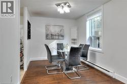 Dining area featuring baseboard heating, and dark wood finished floors - 