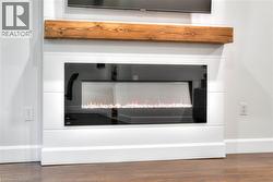 Detailed view of wood finished floors and a lit fireplace - 
