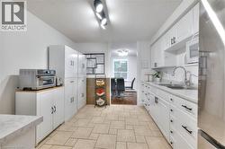 Kitchen featuring light countertops, stainless steel refrigerator, white cabinets, a microwave - 