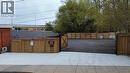 Paved concrete entrance leading to a secure, fenced outdoor area with a dark gravel surface - 43 Glen Road, Hamilton, ON 
