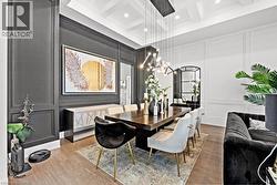Dining area with a decorative wall, wood finished floors, a chandelier, coffered ceiling, and beam ceiling - 