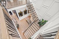 Stairway featuring a towering ceiling and wood finished floors - 