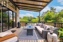 Deck featuring an outdoor living space with a fire pit and view of scattered trees - 