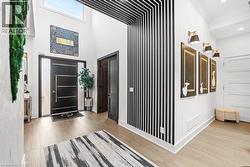 Foyer entrance with wood finished floors, a high ceiling, and ornamental molding - 