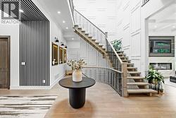 Stairway with wood finished floors, recessed lighting, and a towering ceiling - 