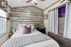 Bedroom with vaulted ceiling, ceiling fan, and ornamental molding - 