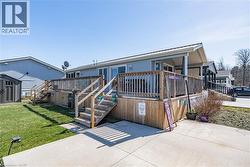 Back of property with a storage unit, stairway, a deck, an outdoor structure, and a yard - 
