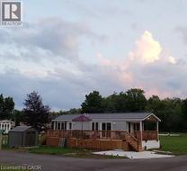 Manufactured / mobile home with a metal roof, a shed, and a wooden deck (prior to neighbouring homes) - 