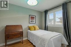 Bedroom featuring wood finished floors and baseboards - 