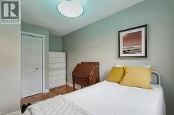 Bedroom featuring wood finished floors and a closet - 