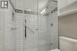 Full bathroom featuring a stall shower and toilet - 