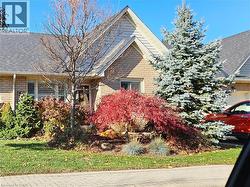 View of front facade featuring brick siding and roof with shingles - 