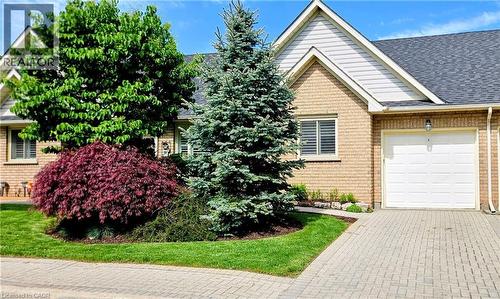 Exterior featuring light brick siding with white gables and a dark shingle roof - 165 Main Street E Unit# 9, Grimsby, ON - Outdoor