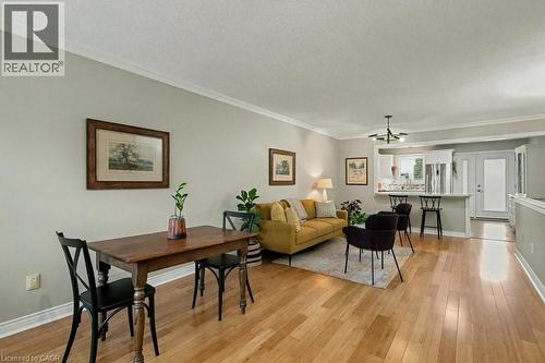 Living area with crown molding, a textured ceiling, and light wood finished floors - 165 Main Street E Unit# 9, Grimsby, ON - Indoor