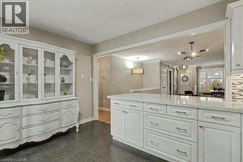 Kitchen with white cabinetry, light stone counters, and hanging light fixtures - 165 Main Street E Unit# 9, Grimsby, ON - Indoor