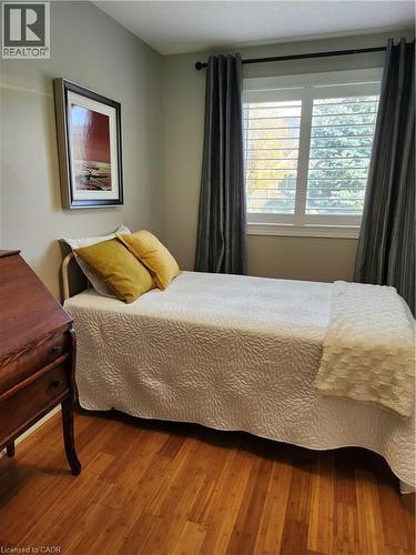 Window featuring white louvered shutters and a black curtain rod - 165 Main Street E Unit# 9, Grimsby, ON - Indoor Photo Showing Bedroom