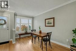 Dining area featuring crown molding, light wood-style flooring, and a textured ceiling - 