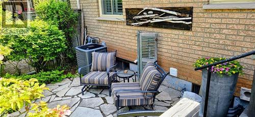 Flagstone patio with surrounding shrubbery and brick exterior - 165 Main Street E Unit# 9, Grimsby, ON - Outdoor With Exterior