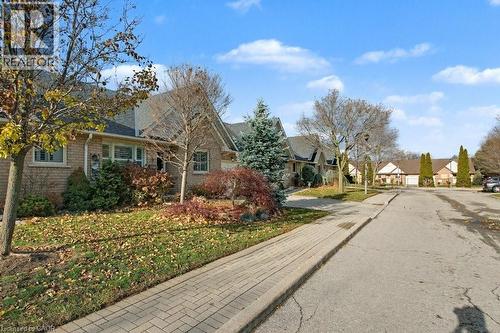 Brick exterior residence with gabled roofline, mature trees, and landscaping - 165 Main Street E Unit# 9, Grimsby, ON - Outdoor