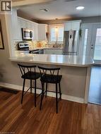 Kitchen with a peninsula, refrigerator, a kitchen bar, and stainless steel range - 