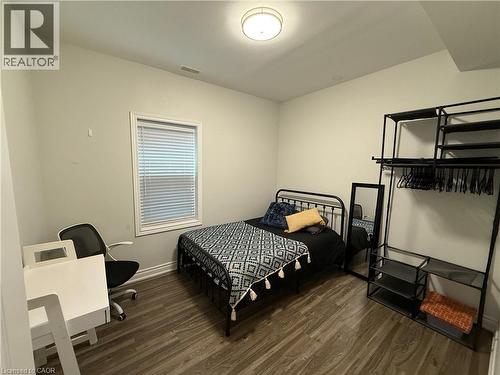 Bedroom with dark wood-style flooring and an office area - 106 Spadina Avenue Unit# 1, Hamilton, ON - Indoor Photo Showing Bedroom