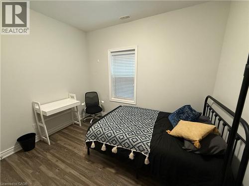 Bedroom with dark wood-style flooring and baseboards - 106 Spadina Avenue Unit# 1, Hamilton, ON - Indoor Photo Showing Bedroom