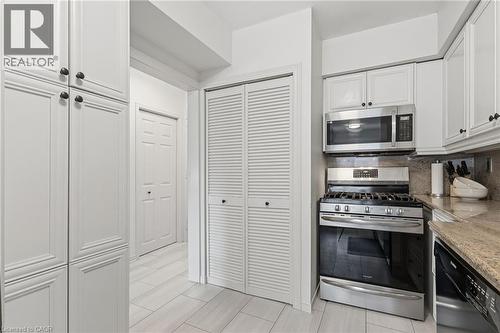 Kitchen featuring stainless steel appliances, white cabinetry, backsplash, and light stone counters - 2069 Meadowbrook Road Unit# 4, Burlington, ON - Indoor Photo Showing Kitchen